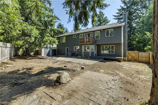 9373 SW Fast Pl, Portland, OR 97223 - back of house with a fenced backyard, a chimney, a gate, and a balcony