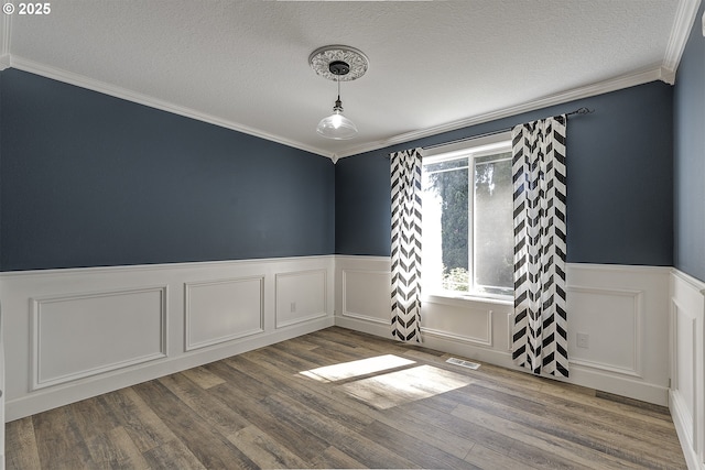 9373 SW Fast Pl, Portland, OR 97223 - unfurnished room featuring wainscoting, crown molding, a textured ceiling, wood finished floors, and a decorative wall