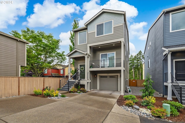 view of front facade featuring driveway, a garage, and fence