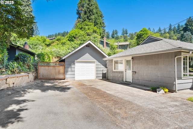 2822 NE Fremont Dr, Portland, OR 97220 - view of front of home featuring a detached garage, roof with shingles, driveway, and an outbuilding