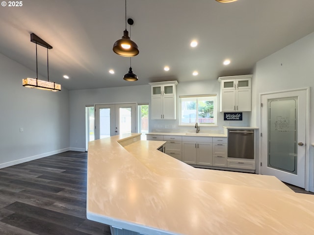 kitchen with french doors, a sink, stainless steel dishwasher, and white cabinetry
