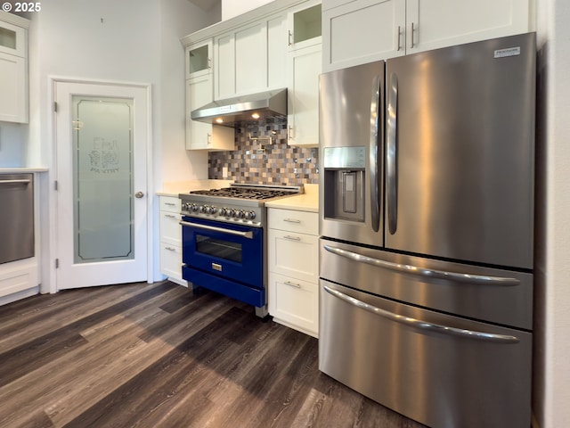 kitchen featuring tasteful backsplash, light countertops, appliances with stainless steel finishes, white cabinets, and under cabinet range hood