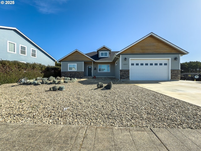 craftsman inspired home with stone siding, an attached garage, and driveway