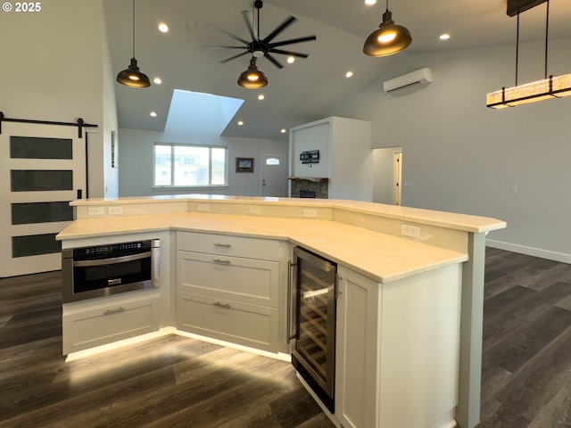 kitchen with a wall unit AC, wine cooler, open floor plan, and oven