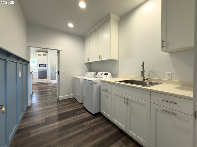 clothes washing area featuring recessed lighting, dark wood-type flooring, a sink, cabinet space, and washer and clothes dryer
