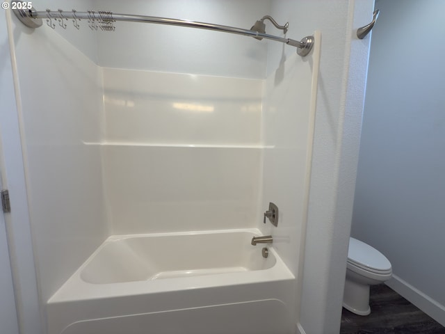full bathroom featuring tub / shower combination, wood finished floors, toilet, and baseboards