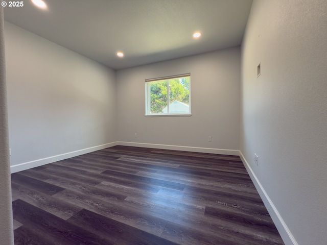 unfurnished room featuring baseboards, dark wood-type flooring, and recessed lighting