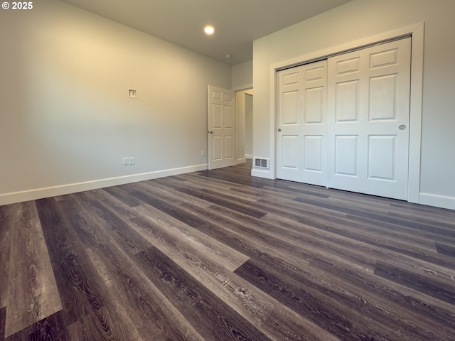 unfurnished bedroom featuring dark wood-style flooring, recessed lighting, a closet, visible vents, and baseboards