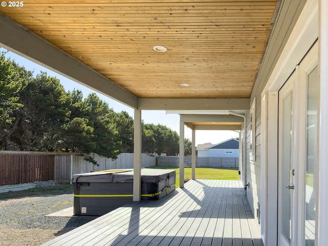 wooden deck with a fenced backyard and a hot tub