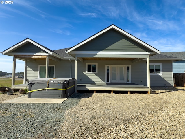 rear view of property with a hot tub and french doors
