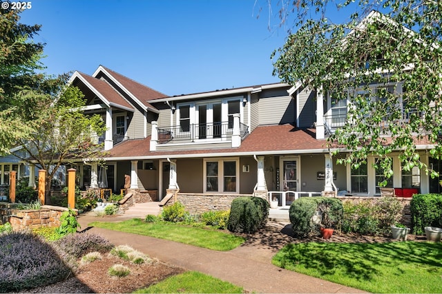 craftsman inspired home featuring covered porch, stone siding, and a balcony