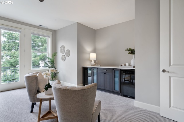 bar with wine cooler, light colored carpet, visible vents, baseboards, and a dry bar