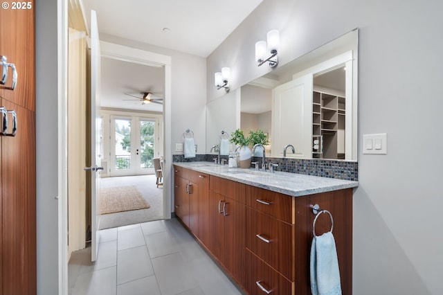 full bath with double vanity, backsplash, a sink, and french doors