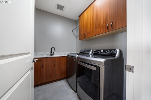 laundry room featuring visible vents, separate washer and dryer, a sink, and cabinet space