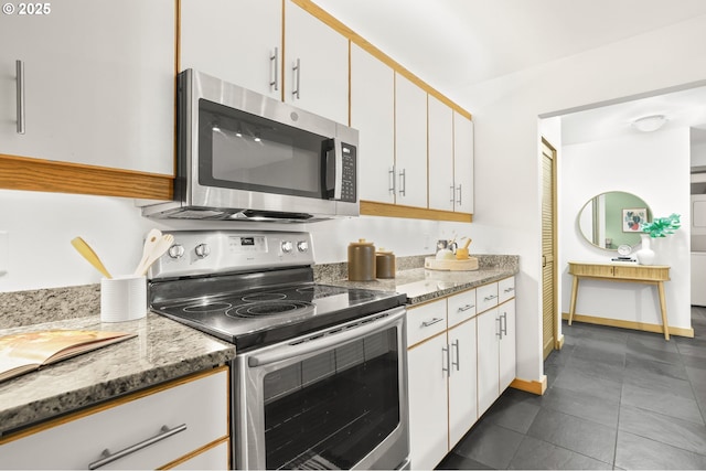 1710 S Harbor Way Unit 201, Portland, OR 97201 - kitchen with stainless steel appliances, white cabinetry, light stone countertops, and dark tile patterned flooring