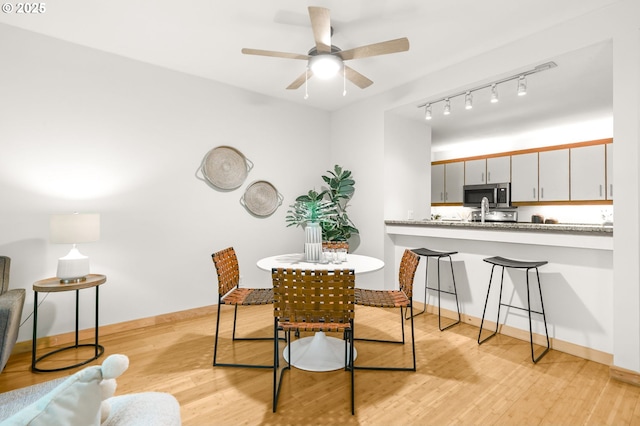 1710 S Harbor Way Unit 201, Portland, OR 97201 - dining room with light wood finished floors, baseboards, a ceiling fan, and rail lighting