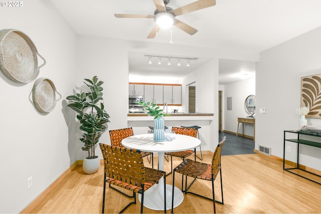 1710 S Harbor Way Unit 201, Portland, OR 97201 - dining room with light wood-style floors, a ceiling fan, rail lighting, and baseboards