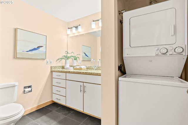 1710 S Harbor Way Unit 201, Portland, OR 97201 - bathroom with stacked washer / dryer, vanity, toilet, tile patterned floors, and baseboards