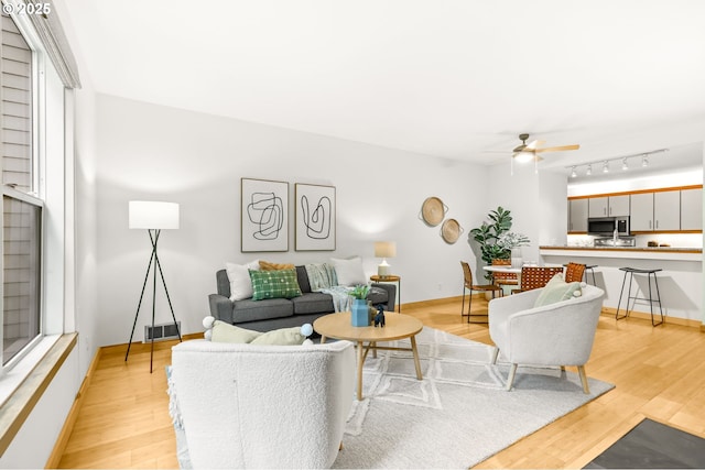 1710 S Harbor Way Unit 201, Portland, OR 97201 - living area with ceiling fan, light wood-style flooring, and baseboards