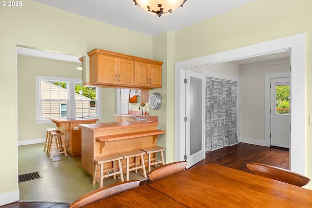 4536 N Haight Ave, Portland, OR 97217 - kitchen featuring a peninsula, baseboards, a kitchen bar, and visible vents