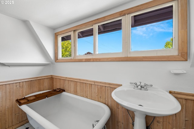4536 N Haight Ave, Portland, OR 97217 - bathroom with wooden walls, a wainscoted wall, a soaking tub, and a sink