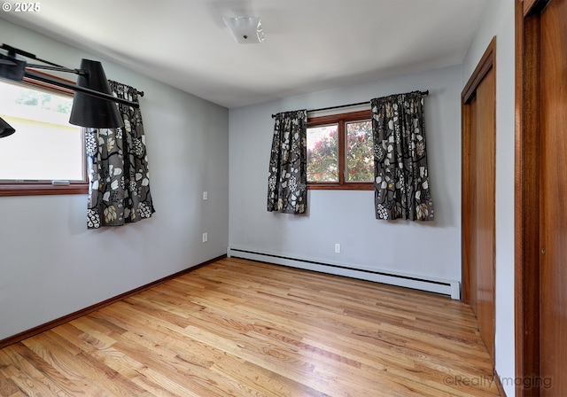 5730 N Harvard St, Portland, OR 97203 - spare room featuring a baseboard radiator, wood finished floors, and plenty of natural light