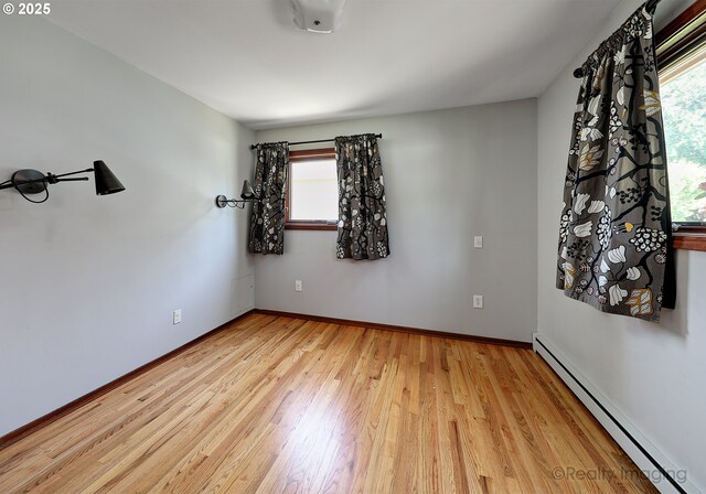 5730 N Harvard St, Portland, OR 97203 - empty room with a baseboard heating unit and light wood-style flooring