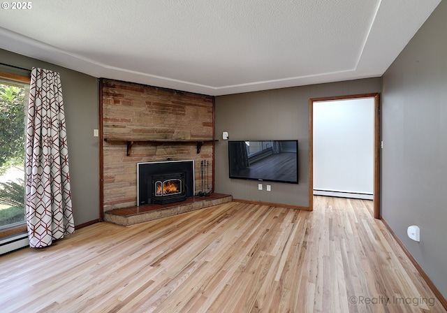 5730 N Harvard St, Portland, OR 97203 - unfurnished living room with a baseboard heating unit, wood finished floors, a fireplace, and baseboards