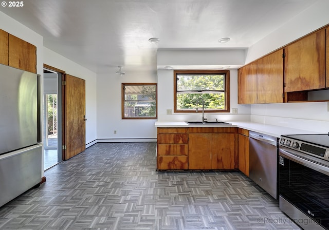 5730 N Harvard St, Portland, OR 97203 - kitchen with stainless steel appliances, a sink, light countertops, and brown cabinets