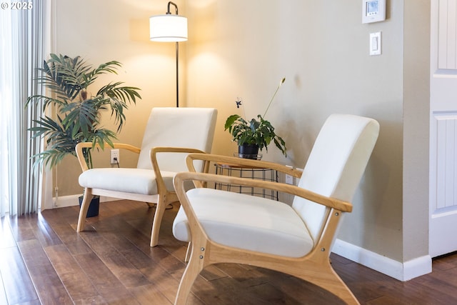 sitting room with baseboards and wood finished floors