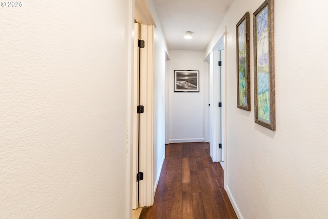 hallway with baseboards and dark wood-style floors