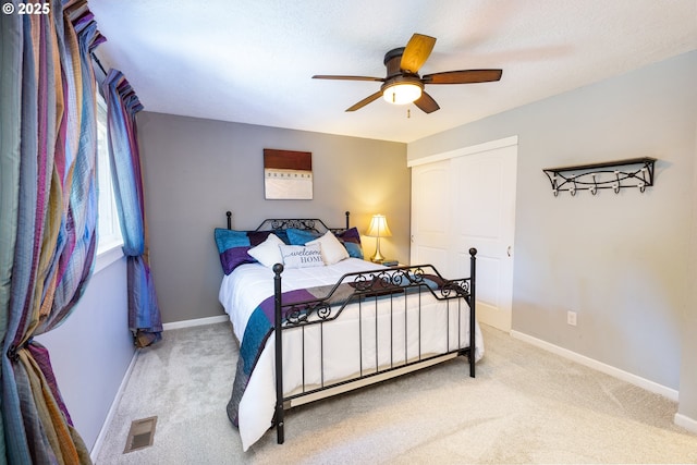 bedroom featuring baseboards, visible vents, ceiling fan, and carpet