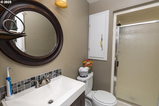 bathroom with vanity, decorative backsplash, a stall shower, and toilet