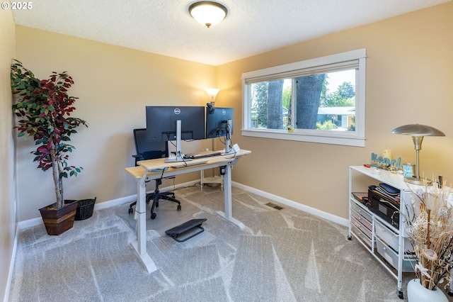 carpeted office space featuring baseboards and a textured ceiling