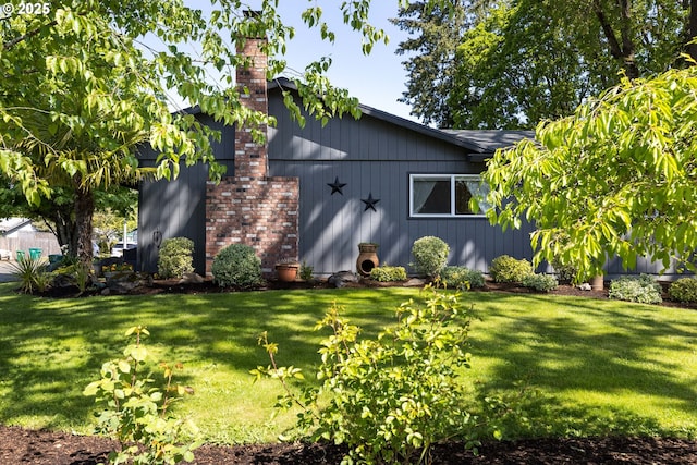 exterior space with a chimney and a front yard