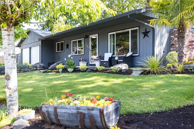 exterior space with an attached garage, a front lawn, and covered porch