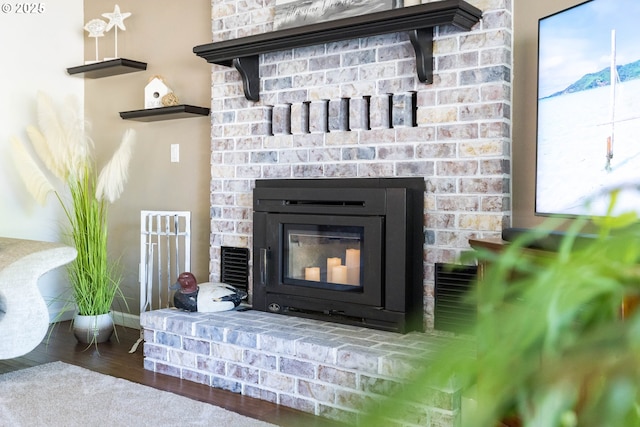 room details featuring baseboards, wood finished floors, and a fireplace