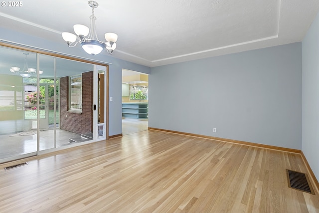1311 NE 116th Ave, Portland, OR 97220 - unfurnished room featuring a chandelier, light wood finished floors, and baseboards