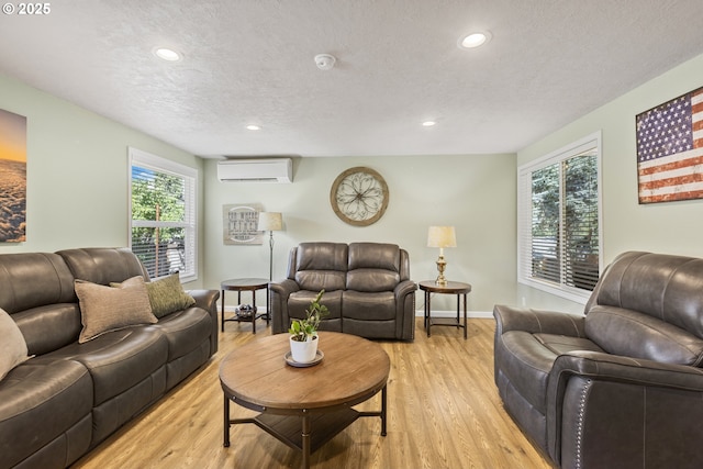 311 S 68th Pl, Springfield, OR 97478 - living area featuring a wall unit AC, light wood finished floors, recessed lighting, and a textured ceiling