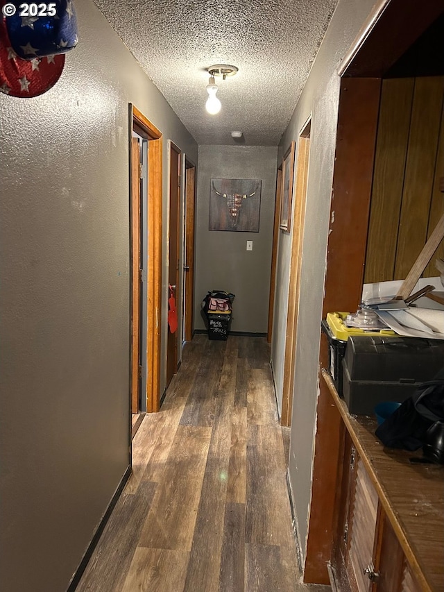 hall featuring a textured ceiling and dark hardwood / wood-style flooring