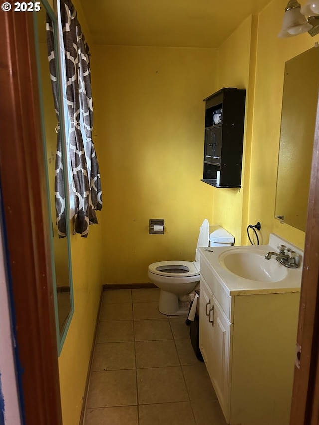 bathroom featuring tile patterned flooring, vanity, and toilet