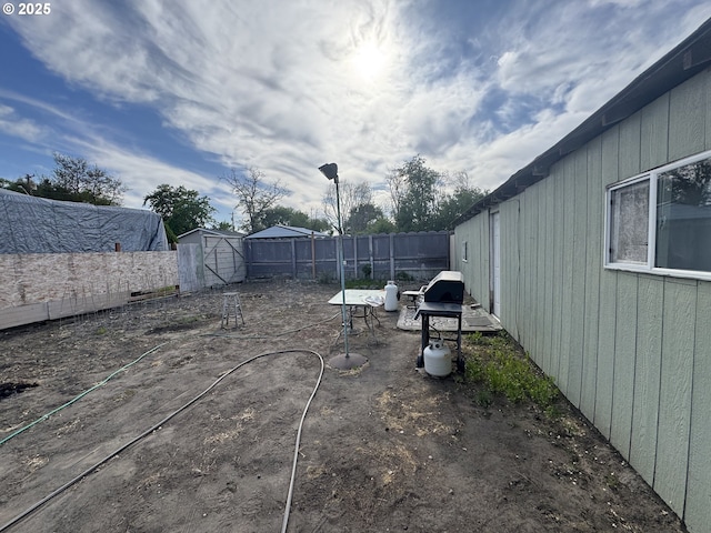 fenced backyard with an outdoor structure and a storage shed