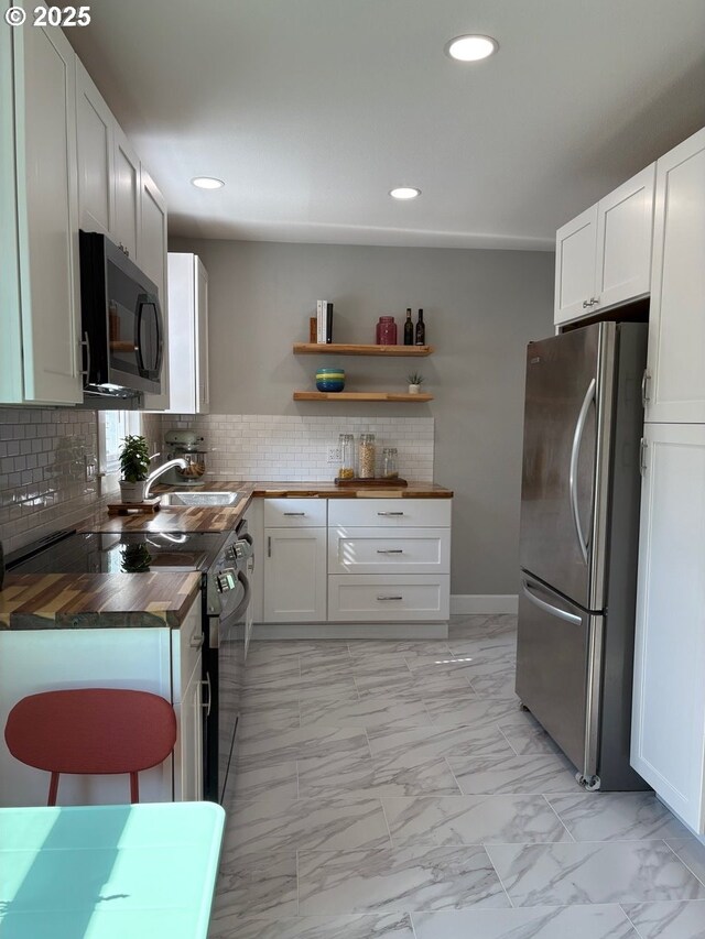708 W 28th St, Vancouver, WA 98660 - kitchen with appliances with stainless steel finishes, wood counters, light marble finish floors, recessed lighting, and tasteful backsplash