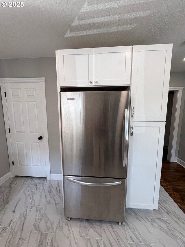 708 W 28th St, Vancouver, WA 98660 - kitchen with freestanding refrigerator, white cabinets, and light marble finish flooring