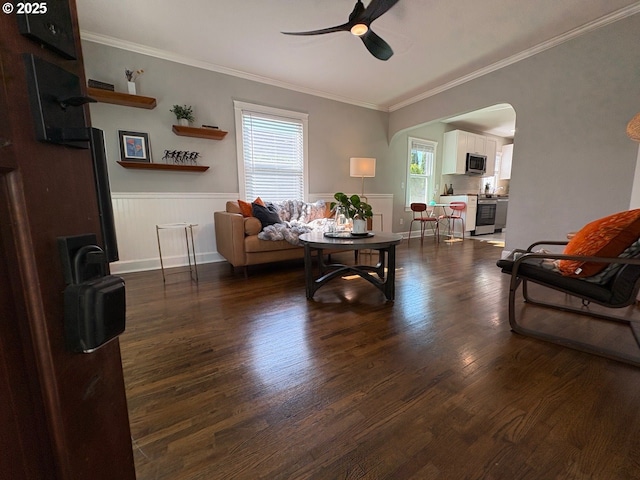 708 W 28th St, Vancouver, WA 98660 - living room with a ceiling fan, ornamental molding, dark wood-style floors, a wainscoted wall, and arched walkways