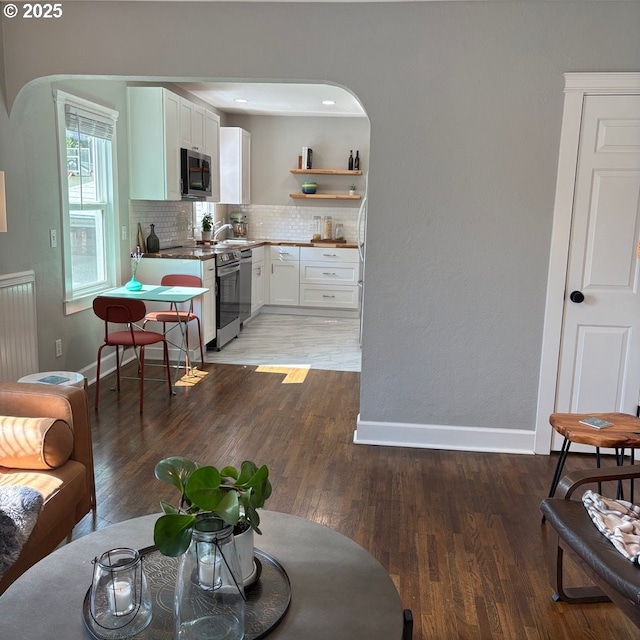 708 W 28th St, Vancouver, WA 98660 - living room featuring arched walkways, light wood-style floors, and radiator heating unit