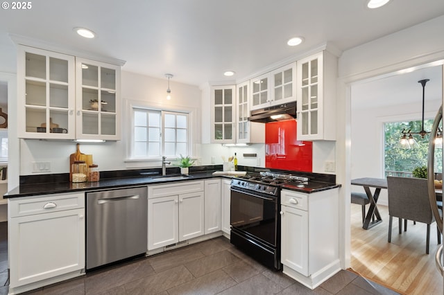 kitchen featuring a sink, under cabinet range hood, gas stove, stainless steel dishwasher, and dark countertops