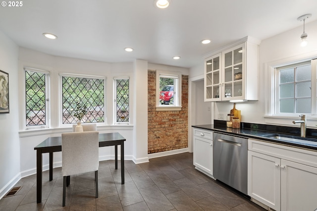 kitchen featuring a sink, dark countertops, stainless steel dishwasher, baseboards, and visible vents