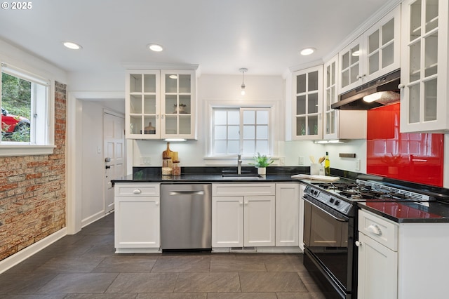 kitchen featuring under cabinet range hood, dishwasher, brick wall, a sink, and black range with gas stovetop