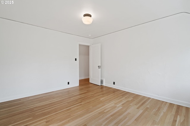 empty room with baseboards, light wood-style flooring, and visible vents